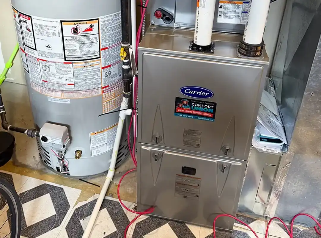 Installed Carrier furnace with connected water heater in basement by Comfort Union